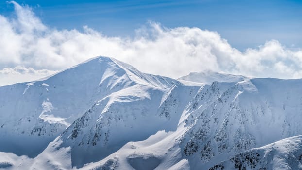 View from Kasprowy Wierch at mountain peak at winter. Amazing mountain range with snow capped mountain peaks in Tatra Mountains, Poland