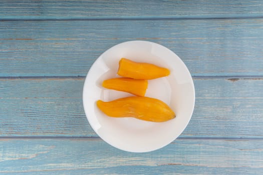 Ubi rebus or steam cassava is traditional malay dish on wooden background. Selective focus