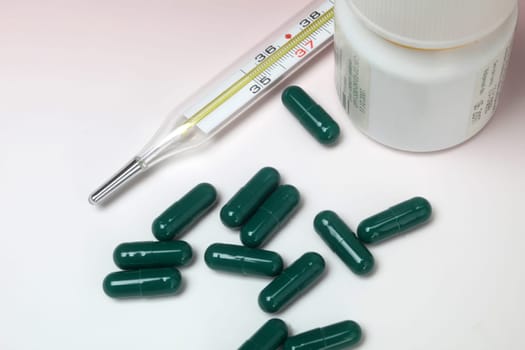 Close-up medical thermometer and pills