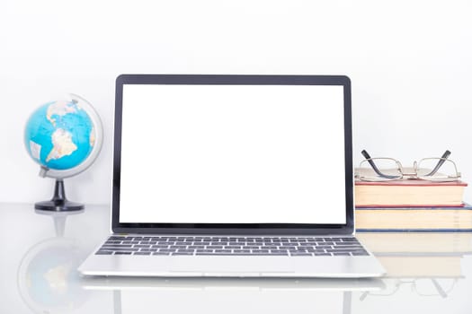 Laptop mockup with blank screen and Eye glasses on book and simulated world on table