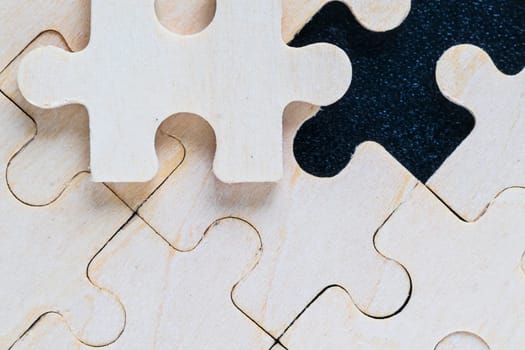 Shot of wooden jigsaw puzzle pieces on black background,Business concept