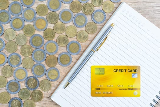 Top view coins with credit card on wood table using as financial concept