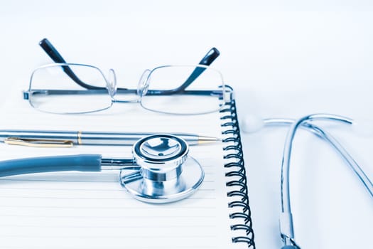 Close up Medical stethoscope with blank notepad as medical concept