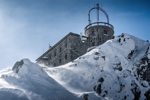 Meteorologic station with transmission antennas on the top of Kasprowy Wierch mountain in rough winter conditions, Poland