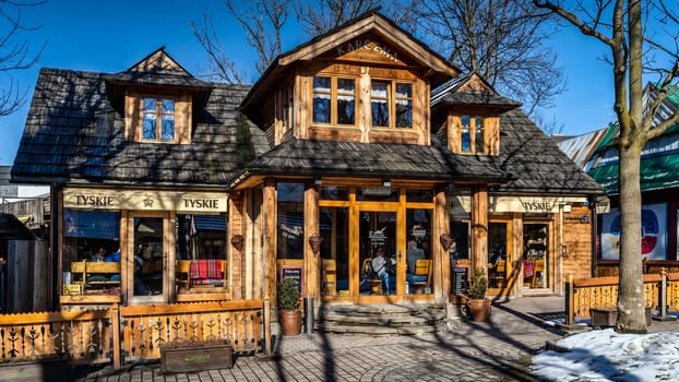 Zakopane, Poland, March 2019 Traditional wooden restaurant on Krupowki promenade, main shopping area. Zakopane is called a winter capital of Poland