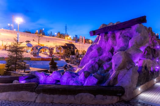 Bialka Tatrzanska, Poland, March 2019 Rock formation and waterfall in ski lift Bania at night time. Popular winter sports village in Tatra Mountains