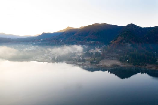 Magic foggy sunrise over Colibita lake at autumn, Romania.