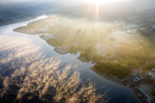 Magic foggy sunrise over Colibita lake at autumn, Romania.