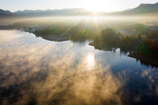 Magic foggy sunrise over Colibita lake at autumn, Romania.