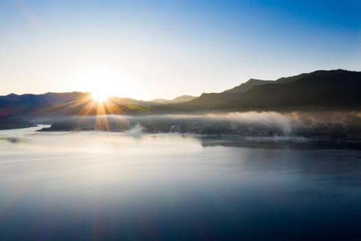 Magic foggy sunrise over Colibita lake at autumn, Romania.