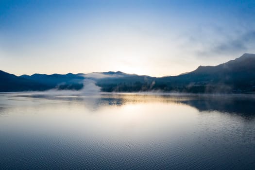 Magic foggy sunrise over Colibita lake at autumn, Romania.