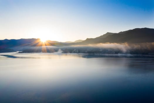 Magic foggy sunrise over Colibita lake at autumn, Romania.