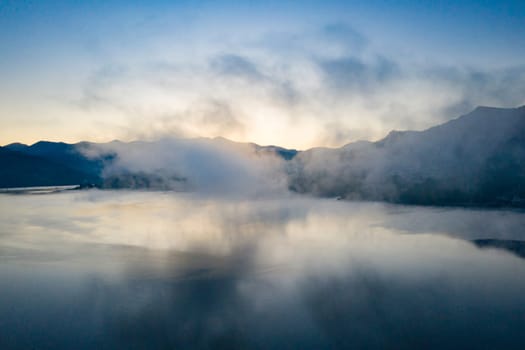 Magic foggy sunrise over Colibita lake at autumn, Romania.