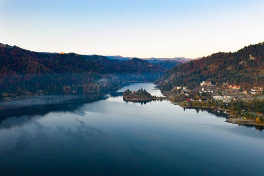 Magic foggy sunrise over Colibita lake at autumn, Romania.