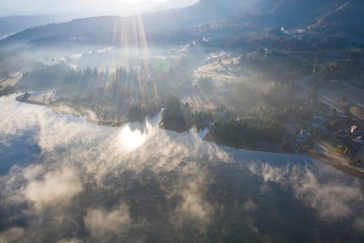 Magic foggy sunrise over Colibita lake at autumn, Romania.