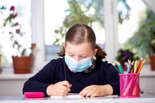 School child wearing mask for protection against coronavirus in school. Measures to prevent the spread of COVID-19 at schools during coronavirus pandemic.