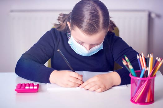 School child wearing mask for protection against coronavirus in school. Measures to prevent the spread of COVID-19 at schools during coronavirus pandemic.