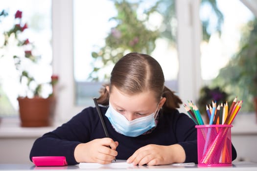 School child wearing mask for protection against coronavirus in school. Measures to prevent the spread of COVID-19 at schools during coronavirus pandemic.