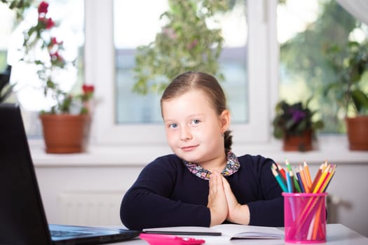 Distance learning-online education. School girl watching online education classes and doing school homework. COVID-19 pandemic forces children online learning.