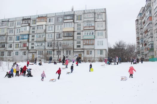 many town and joy children are sleding from the hill