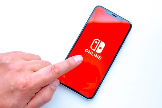 Calgary, Alberta, Canada. Sep 23, 2020. A person using an iPhone 11 Pro Max with the Nintendo Switch app on the screen.