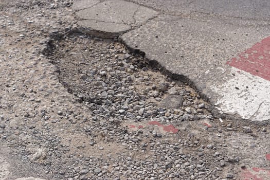 Very big and deep pothole in tarmac at street
