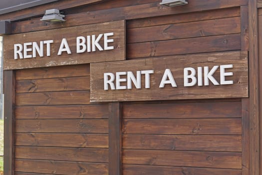 Rent a bike sign at wooden cabin
