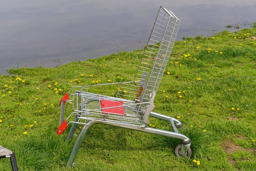 Chair made from recycled shopping cart at grass