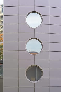 Three round windows at modern building wall