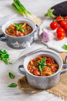 Delicious Italian vegetable minestrone soup served in small pots with ingredients