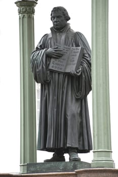 The Martin Luther Monument in Wittenberg . He holds his Bible in his hand. The statue stands on the market square in front of the town hall. Top 10 from Saxony-Anhalt East Germany.