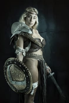 Ancient woman warrior or Gladiator posing in a dark background