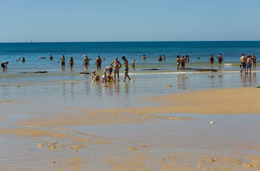ALBUFEIRA, PORTUGAL - AUGUST 20, 2016: People at the famous beach of Olhos de Agua in Albufeira. This beach is a part of famous tourist region of Algarve.