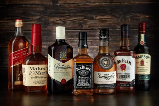 St.Petersburg, Russia - April  2020 - Bottles of several most popular whiskey (whisky) brands on dark wooden background.