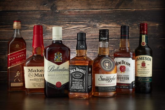 St.Petersburg, Russia - April  2020 - Bottles of several most popular whiskey (whisky) brands on dark wooden background.