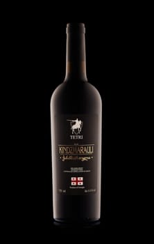 St.Petersburg, Russia - February 2020 - Bottle of  Kindzmarauli red semi-sweet Georgian  wine on black background. Produced in Georgia.