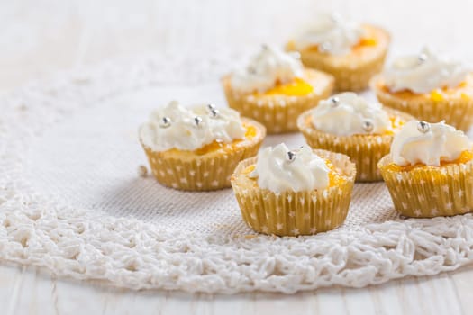 Homemade lemon curd cupcakes with whipped cream on kitchen table