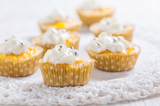 Homemade lemon curd cupcakes with whipped cream on kitchen table