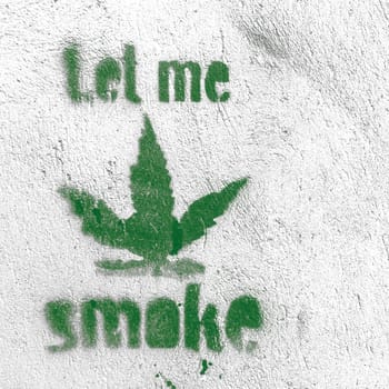 Marijuana leaf symbol on grungy wall with "smoke"" message"