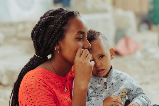 Inticho, Tigray Region, Ethiopia - April 28, 2019: Ethiopian beautiful local women with son looking to visitors on the street of Inticho city, Ethiopia, Africa