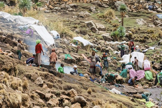 SIMIEN MOUNTAIN, ETHIOPIA, APRIL 25th.2019, Ethiopian women wash clothes in the traditional way way outside in a creek in Simien Mountains, Ethiopia, April 25. 2019