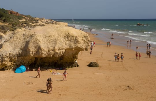 ALBUFEIRA, PORTUGAL - AUGUST 25, 2016: People at the famous beach of Olhos de Agua in Albufeira. This beach is a part of famous tourist region of Algarve.