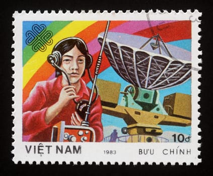 Stamp printed in Vietnam shows Radiooperator and antenna, World Communication Year, circa 1983.