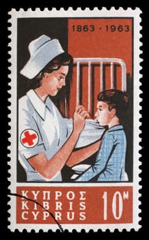Stamp printed in Cyprus shows Centenary International Red Cross - Nurse tending child, circa 1963.