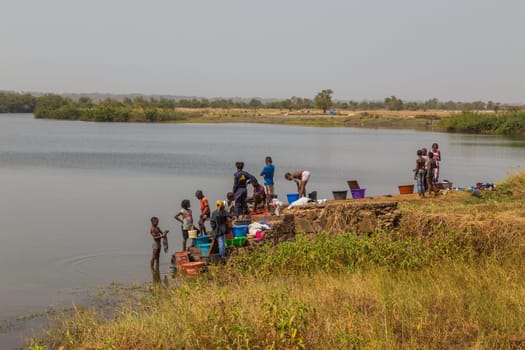 Bissau, Guinea-Bissau - January 5, 2020: group of African Kids playing in the river, in rural Guinea-Bissau