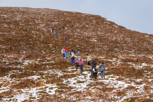 CO KERRY, IRLAND - FEBRUARY 4, 2019: People climbing in the snow at the Paps of Anu, Co Kerry, Ireland