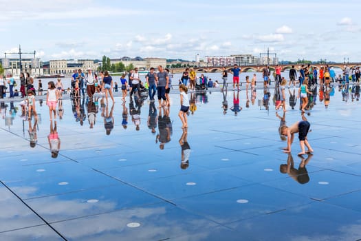 BORDEAUX, FRANCE: The Famous Bordeaux water mirror full of people having fun in the water, in Bordeaux, France.