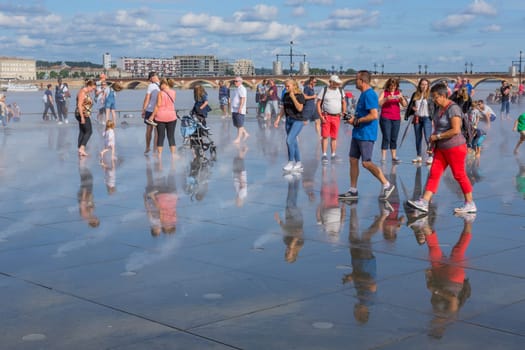 BORDEAUX, FRANCE - AUGUST 11: The Famous Bordeaux water mirror full of people having fun in the water, on August 11, 2019 in Bordeaux, France.