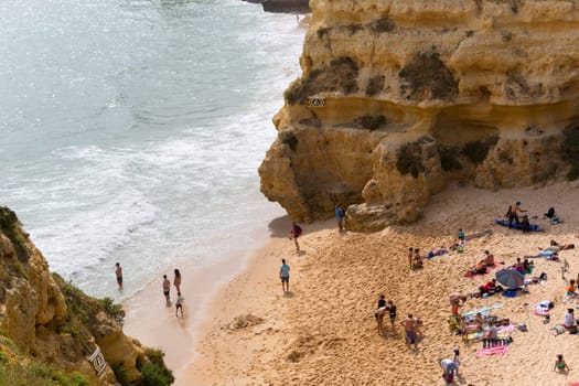 PRAIA DA MARINHA, PORTUGAL - APRIL 24, 2017: People at the famous beach of Praia da Marinha in Lagoa. This beach is a part of famous tourist region of Algarve.