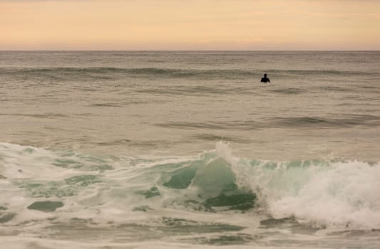 LA VEGA, ASTURIAS, SPAIN. 31 MAY, 2017: Surfers on the beach of La Vega, at dusk, near Llanes, Asturias, Spain
